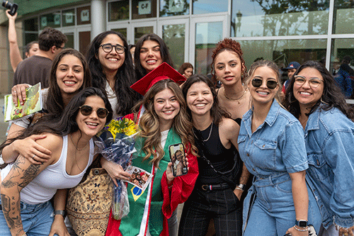 Garcia Lemos stands in the center of a large group of friends and family post-graduation.