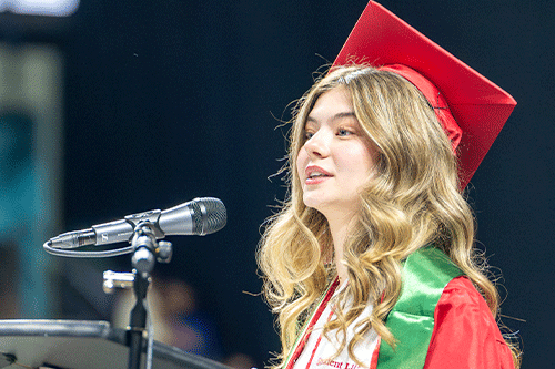 Camila Garcia Lemos speaks at 2024 commencement in her cap and gown.