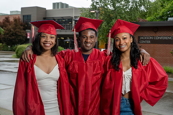 Jamira Barnes with friends Aiden Luhr and Layanah Brewer in graduation caps and gowns