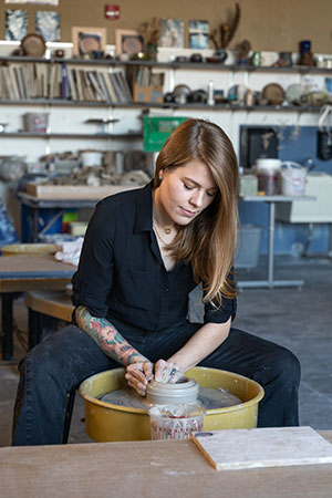 Ceramics student Jessica Mudd works clay on a pottery wheel in the ceramics studio