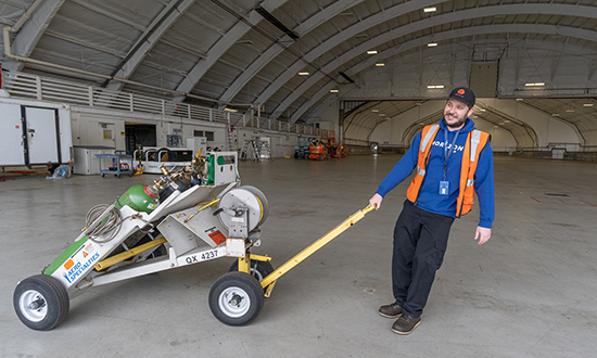 Ryan Nelson moves equipment in an airplane hanger at Horizon Air.