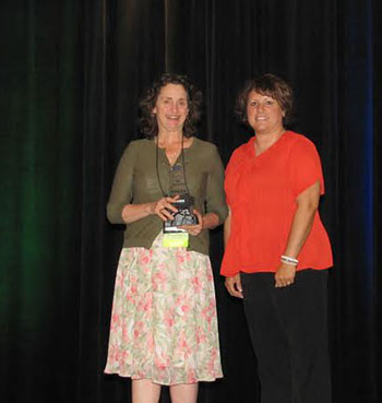 Elizabeth Stam receives her educator of the year award from ADHI.