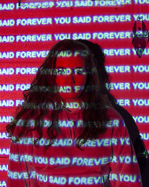 Hannah Hoskins- photo of a woman with the phrase 'You said forever' projected on her.